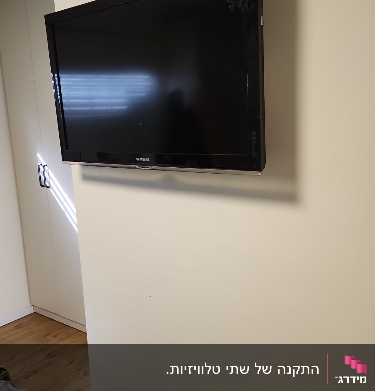 טלוויזיה תלויה על קיר עם כבל חשמל